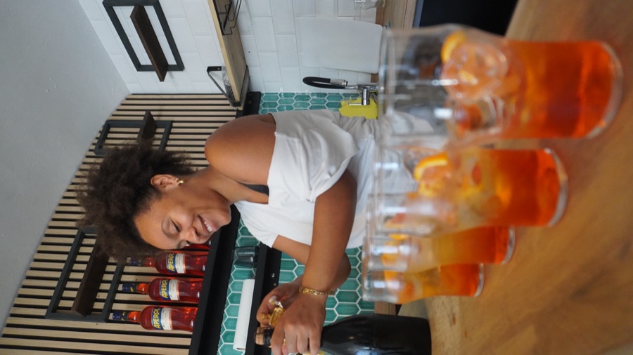 Eine Reihe Aperol Spritz auf dem Holztresen von tiratisù